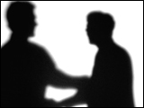 Video Clip - Human figures depicted in black in front of a white background; walking up and shaking hands