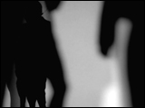 Video Clip - Human figures depicted in black in front of a white background; speaking on the phone outside