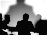 Video Clip - Human figures depicted in black in front of a white background; board meeting