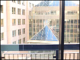 Video Clip - Man in business attire walks up to his building window and looks out
