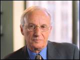 Video Clip - An older man with glasses in business attire looking into the camera