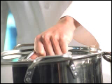 Video Clip - A chef opening a stainless steel pot and looks into the camera